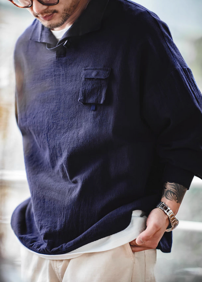 Blue textured cotton polo shirt close-up view highlighting jacquard weave texture and flap chest pocket detail