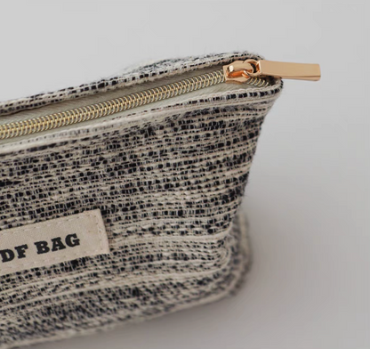 Close-up of Textured Stripe Mini Cosmetic Zip Pouch in stripe pattern featuring textured fabric and gold-tone top zipper