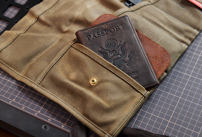 Field Companion canvas roll with passport inserted in leather pocket on table.