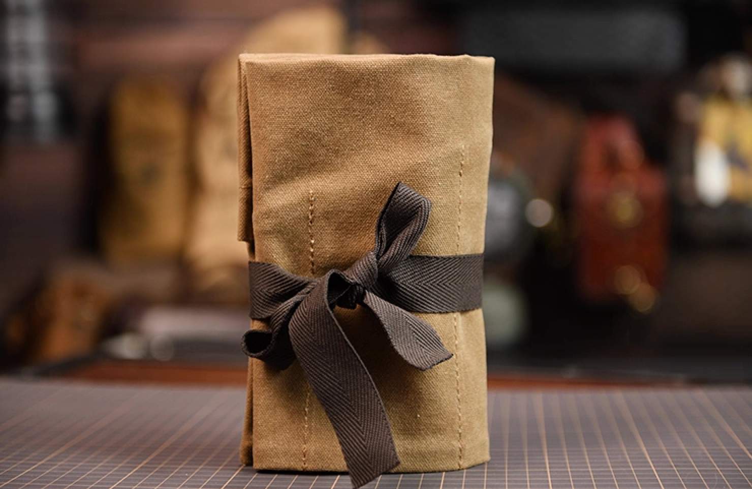 Khaki Field Companion roll standing upright tied with brown strap in workshop.