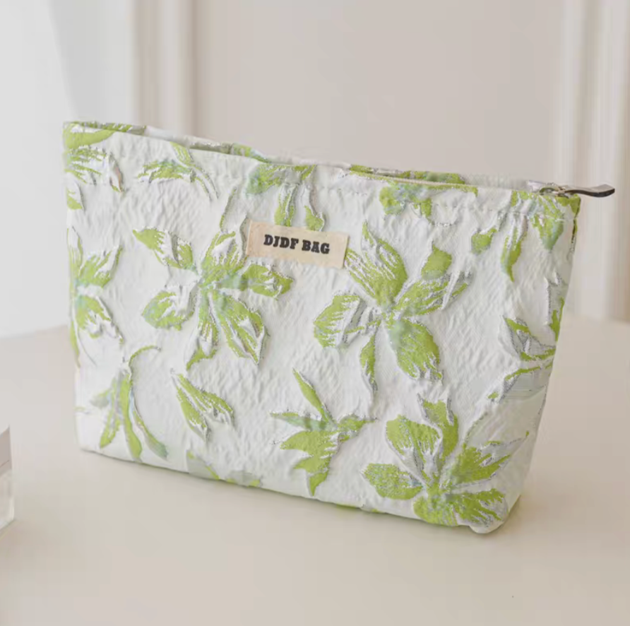 Timeless Elegance Portable Makeup Bag in green and gold floral pattern standing upright showing textured botanical design