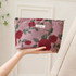 Timeless Elegance Portable Makeup Bag in peony flower pattern held in hand showing soft pink fabric with red floral design