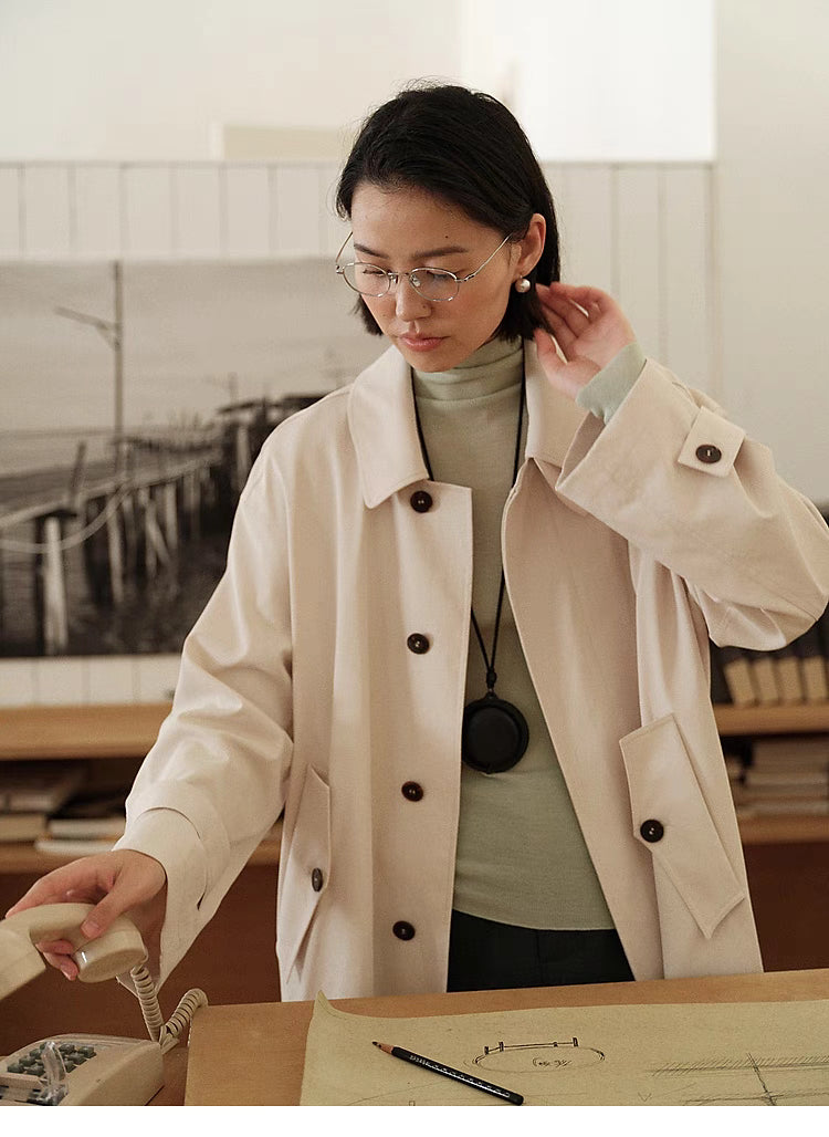 Close-up of Tea Beige Timeless Trench Coat highlighting horn buttons, lapel collar and smooth fabric finish