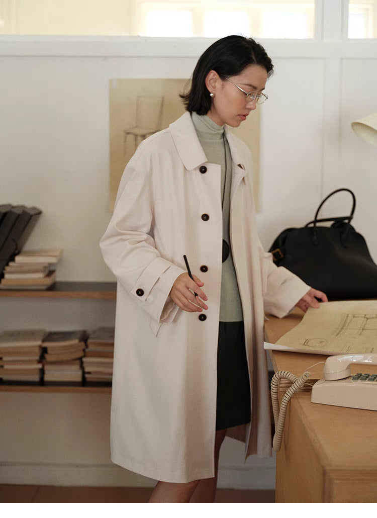 Tea Beige Timeless Trench Coat front view in office setting showing button front, straight fit and everyday styling