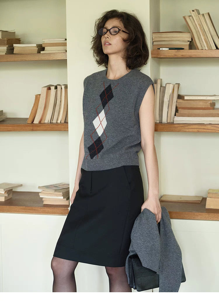 Light gray Timeless Wool Knit Vest side view on model holding cardigan, layered styling with diamond pattern wool knit