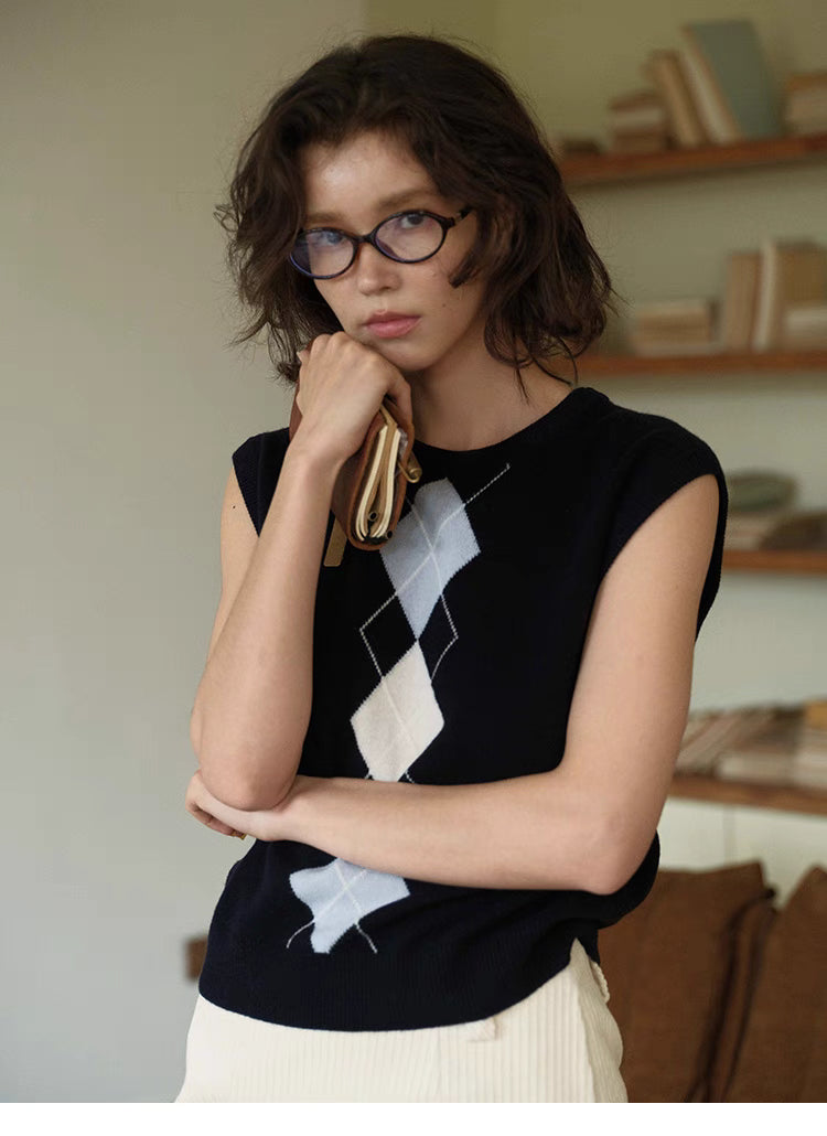 Timeless Wool Knit Vest in navy blue, front view on model with white skirt and classic diamond argyle knit design