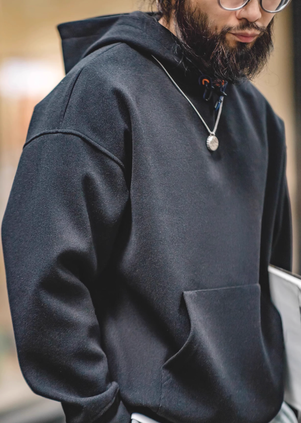 Close-up of model wearing Trailblazer Pullover Hoodie in black highlighting soft fabric texture and relaxed fit