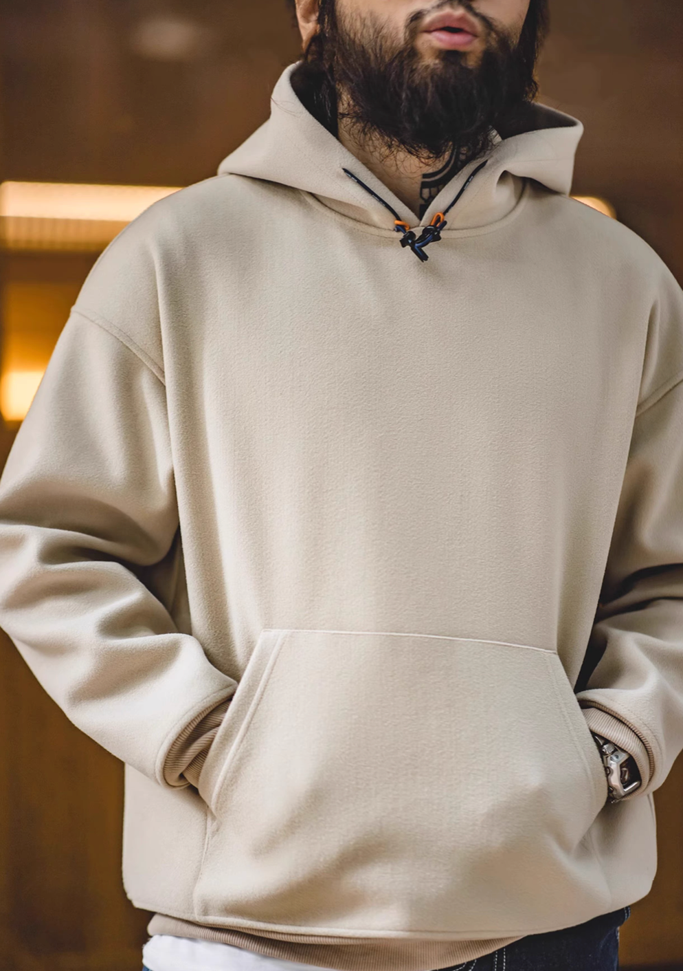 Model wearing Trailblazer Pullover Hoodie in khaki front view with hands in kangaroo pocket in casual styling