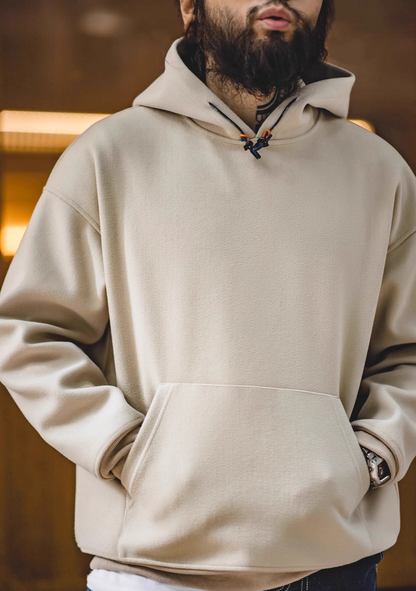 Model wearing Trailblazer Pullover Hoodie in khaki front view with hands in kangaroo pocket in casual styling