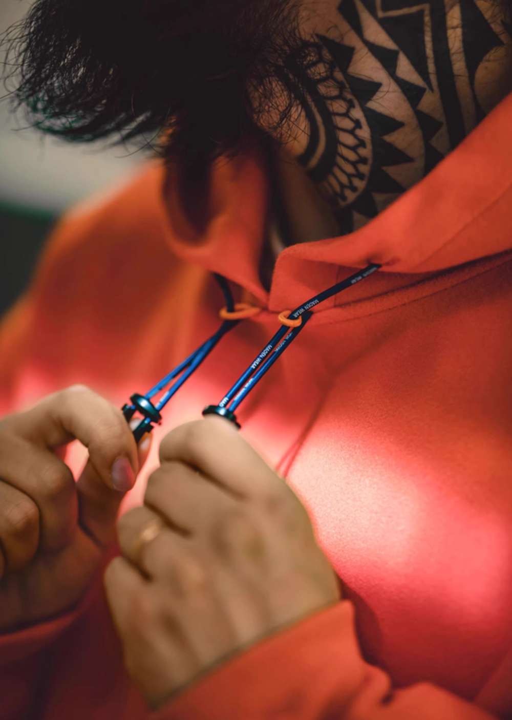 Close-up of Trailblazer Pullover Hoodie in orange showing adjustable drawstring toggle and hood detail