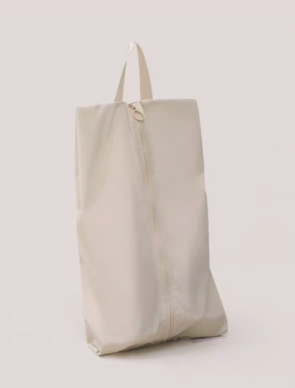 Travel Shoe Dust Bag in beige color standing upright with zipper closure and top handle for easy carrying