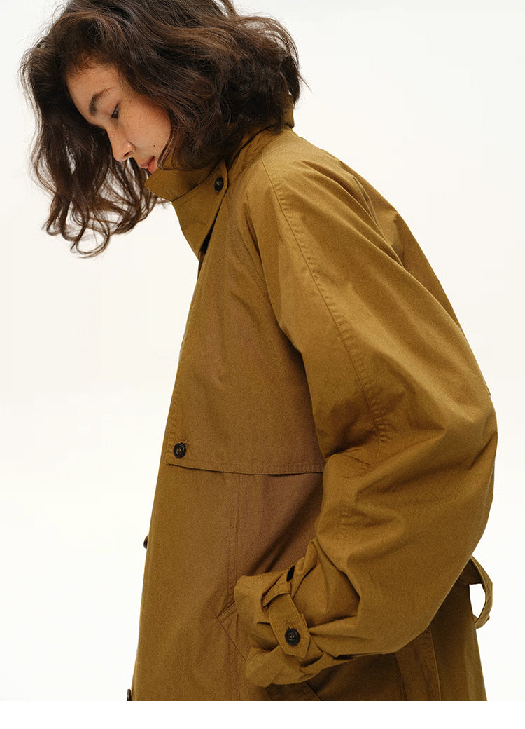 Close-up side profile showing sleeve and shoulder detail of maple brown trench coat.