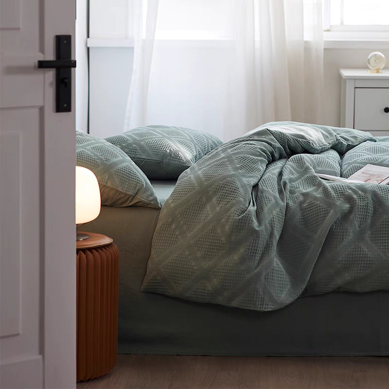 Greenish blue ultra-soft organic cotton waffle weave bedding set styled on modern bed with textured duvet cover