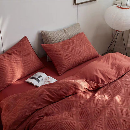 Red organic cotton waffle weave bedding set with textured pillow shams and duvet cover displayed on modern bed