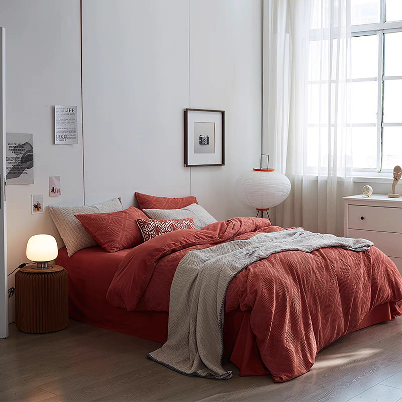 Red organic cotton waffle weave duvet cover bedding set on full bed in bright modern bedroom with soft breathable cotton texture