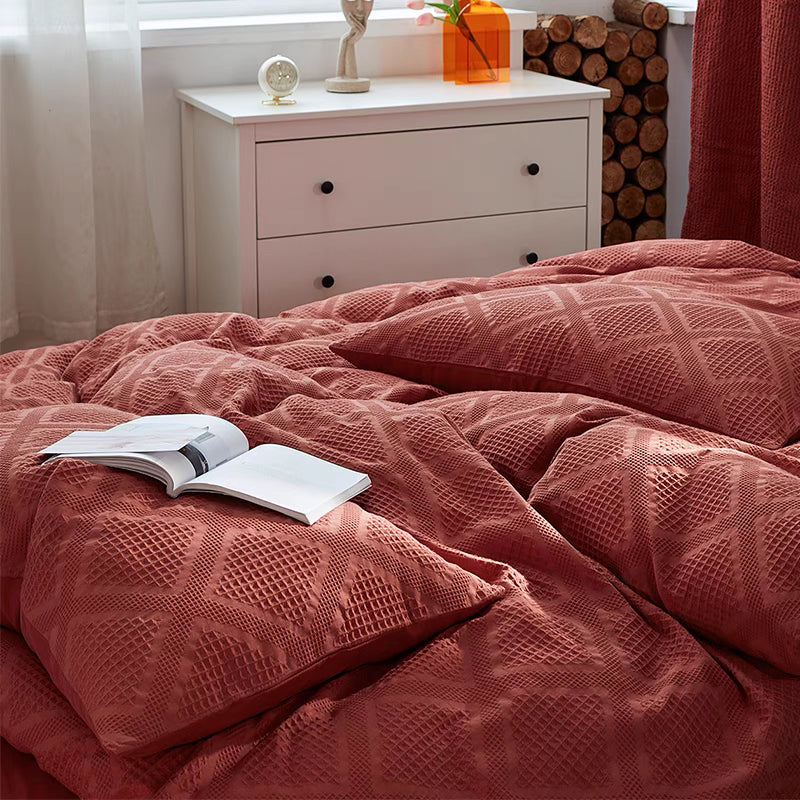 Close-up of red waffle weave organic cotton duvet cover showing soft breathable 60S cotton texture and geometric woven pattern