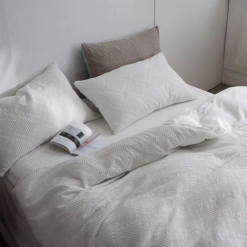 White waffle weave organic cotton duvet cover and pillow shams viewed from above showing breathable textured fabric