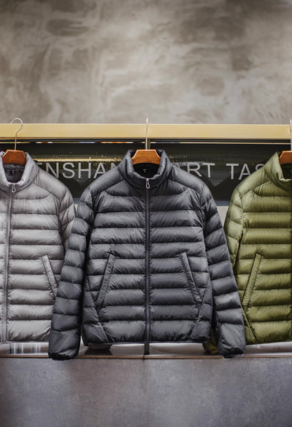 Three Ultra-Light Down Jackets in Light Grey, Dark Grey, and Olive Green on display