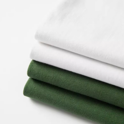 Urban Forest Tee white and avocado green folded cotton t-shirts stacked showing soft fabric texture