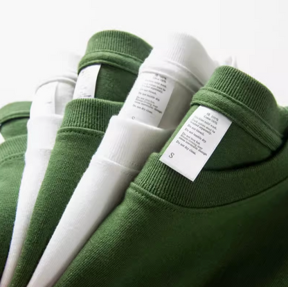 Urban Forest Tee white and avocado green stacked t-shirts with visible care labels showing cotton fabric details