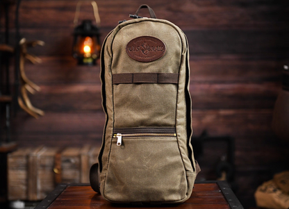 Front view of U.S. Mail waxed canvas backpack in army green with leather patch and front zipper.