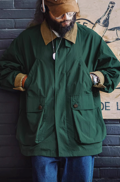 Dark Green Utility Field Jacket worn with hands in pockets demonstrating spacious front flap pockets and casual styling