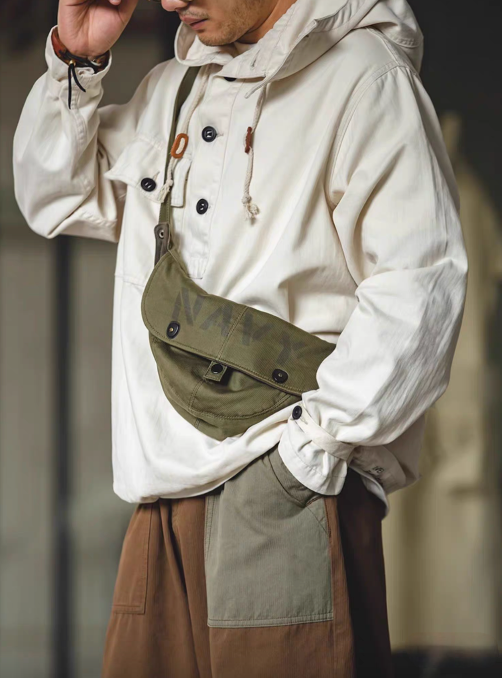 Man wearing Off-White Utility Pocket Hooded Pullover Jacket with crossbody bag showing relaxed fit and vintage workwear styling