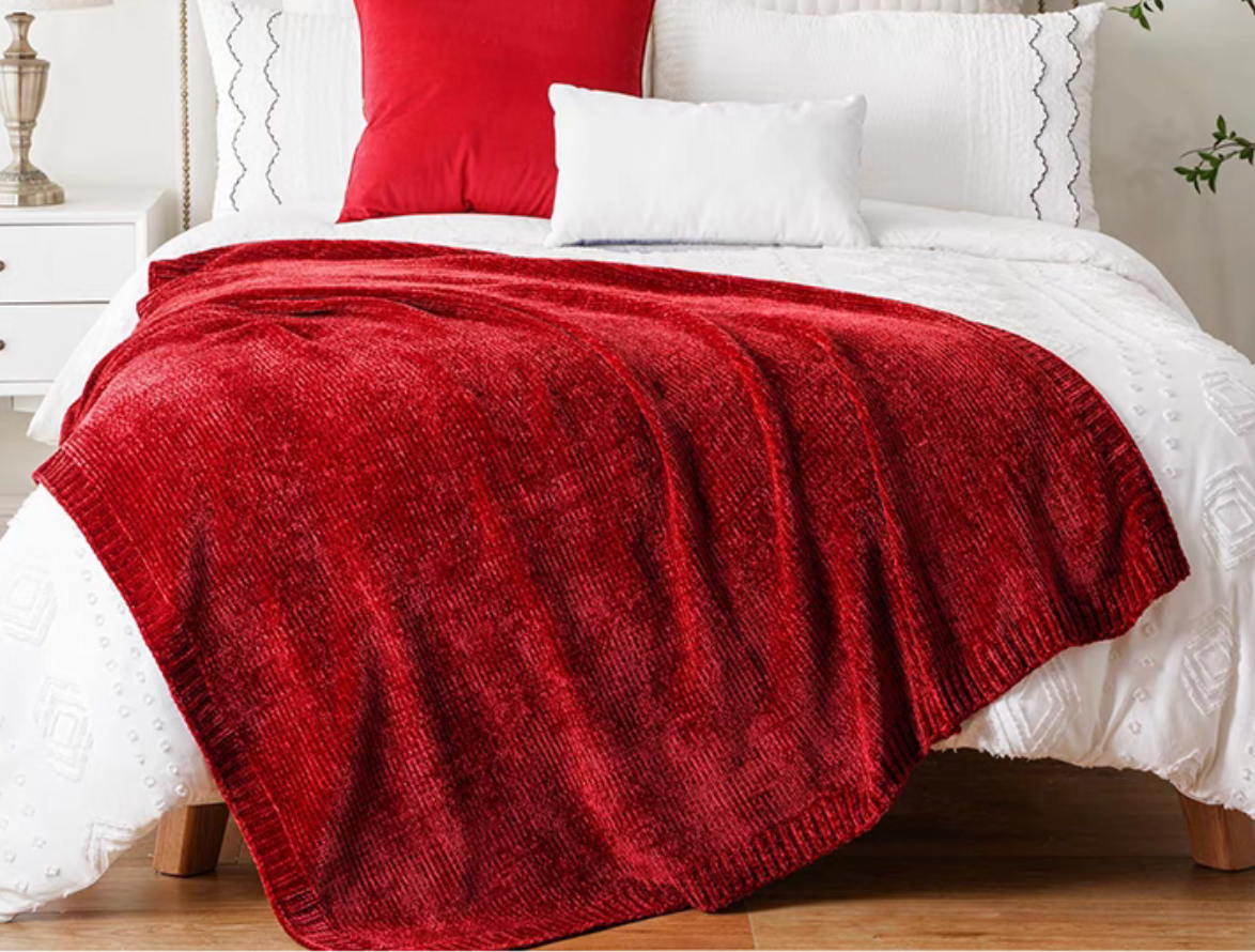 Burgundy vertical rib chenille knit solid throw blanket spread across a white bed