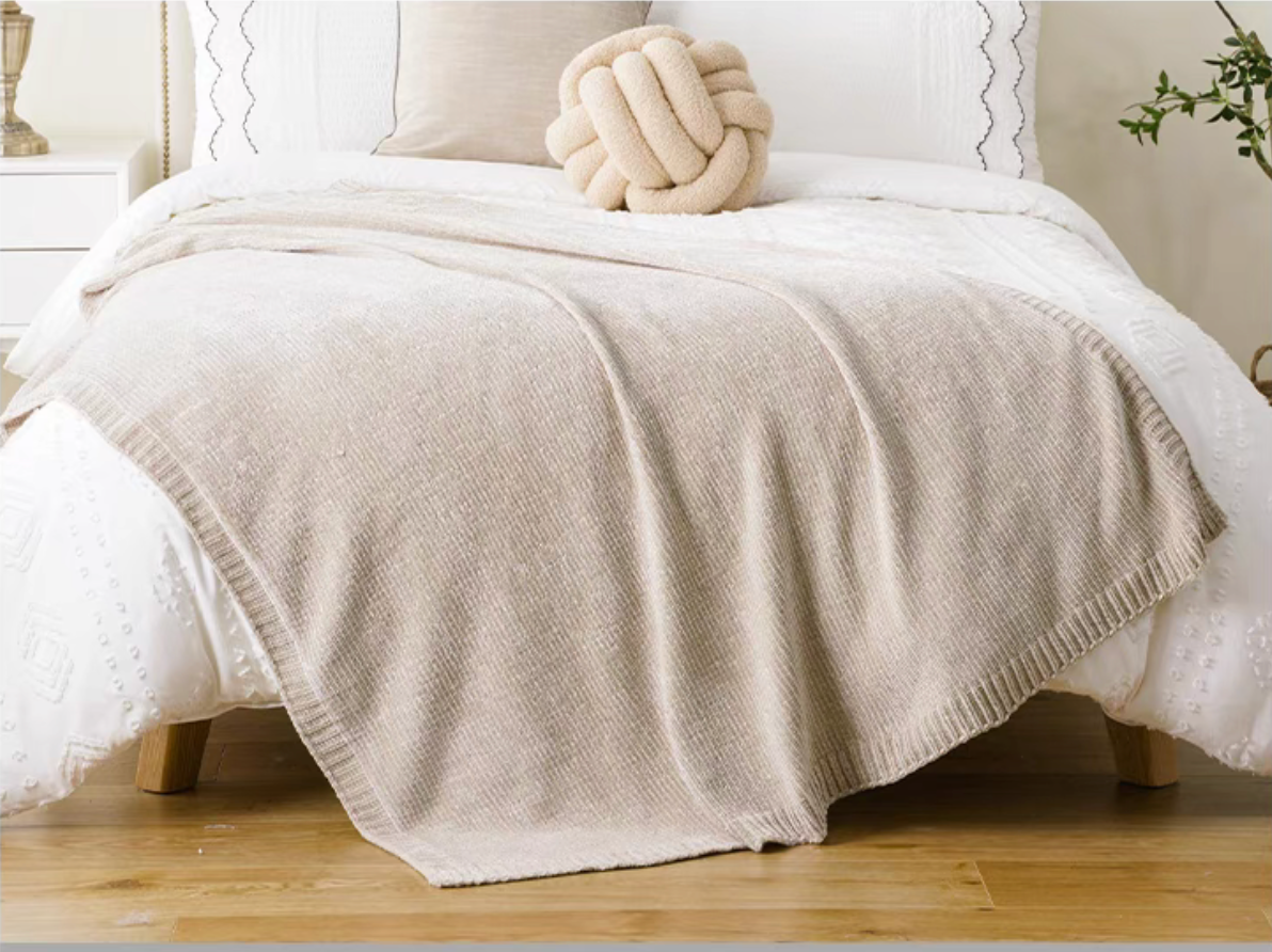 Khaki vertical rib chenille knit solid throw blanket spread across a white bed