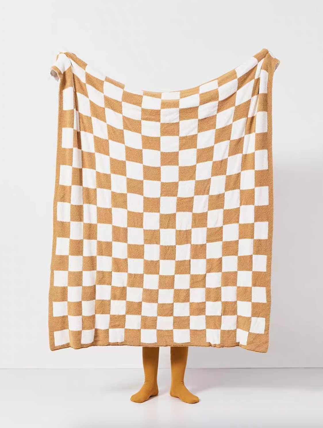 Light khaki and white checkered blanket fully extended in air with clean symmetrical checker layout