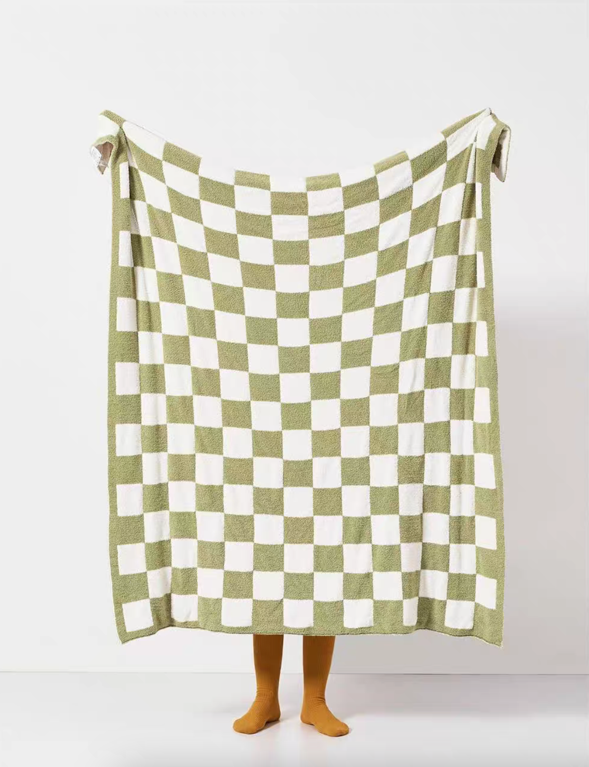 Matcha green and white checkered blanket held open in full display showing soft knit texture and uniform pattern