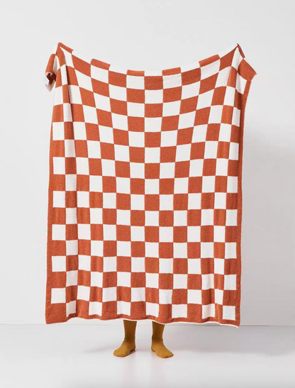 Watermelon red and white checkered blanket held open in full view highlighting bold contrast checker pattern