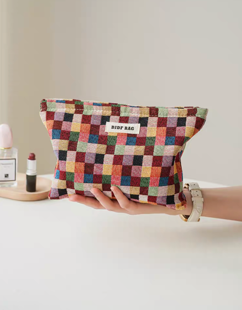 Large size Vibrant Checkered Travel Makeup Bag in multi-colored checkered pattern held in hand showing compact travel size