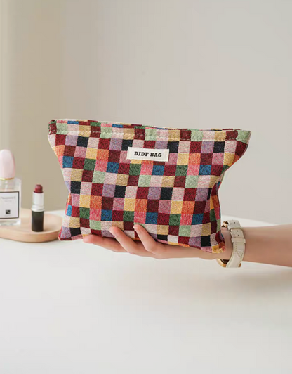 Large size Vibrant Checkered Travel Makeup Bag in multi-colored checkered pattern held in hand showing compact travel size