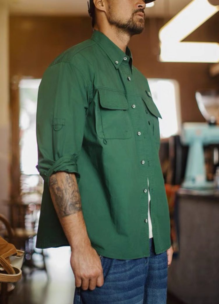 Three-quarter view of model wearing green utility shirt paired with denim