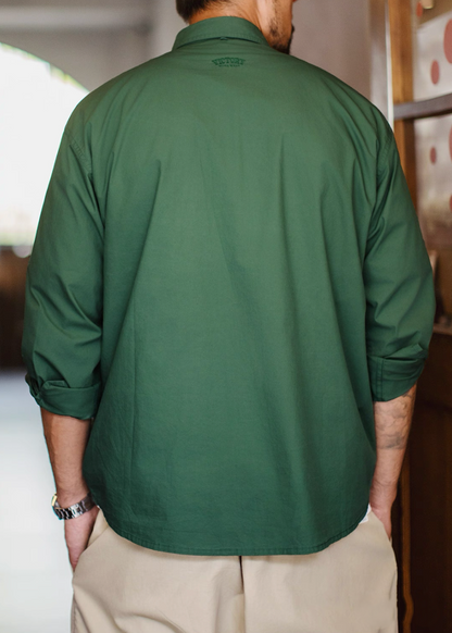 Rear view of model wearing hunter green Victory utility shirt with rolled sleeves