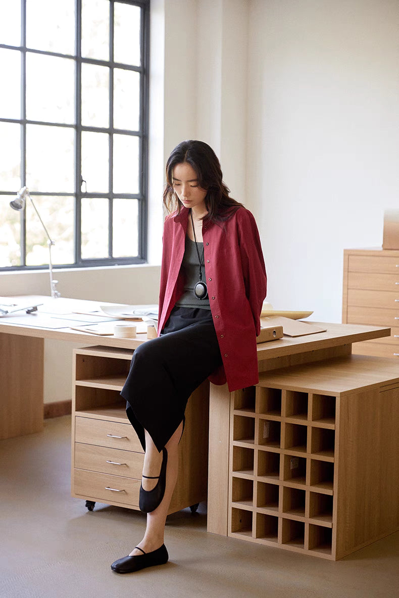 Woman wearing burgundy Vintage Air-Washed Cotton Shirt sitting on desk, full body view highlighting relaxed fit, breathable cotton, and casual styling