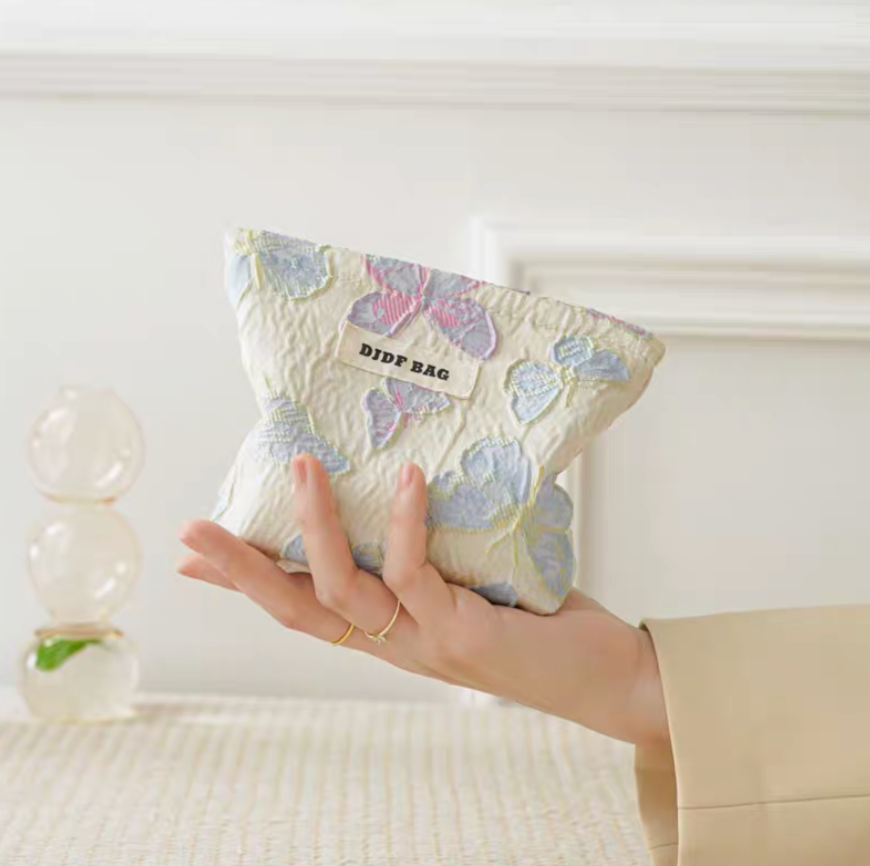 Vintage Butterfly Pattern Portable Makeup Bag in laser butterfly design small pouch held in hand under soft lighting