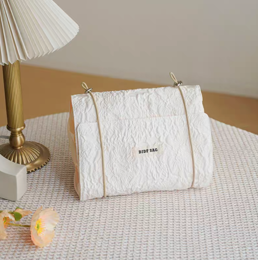 Vintage Chic Waterproof Travel Makeup Bag in white color displayed upright on table with minimal clean aesthetic and soft lighting