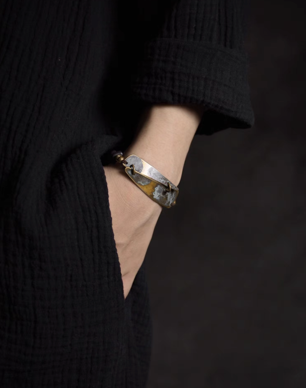 Vintage ebony and brass bracelet worn on wrist, featuring coffee brown wood beads and rustic copper brass design