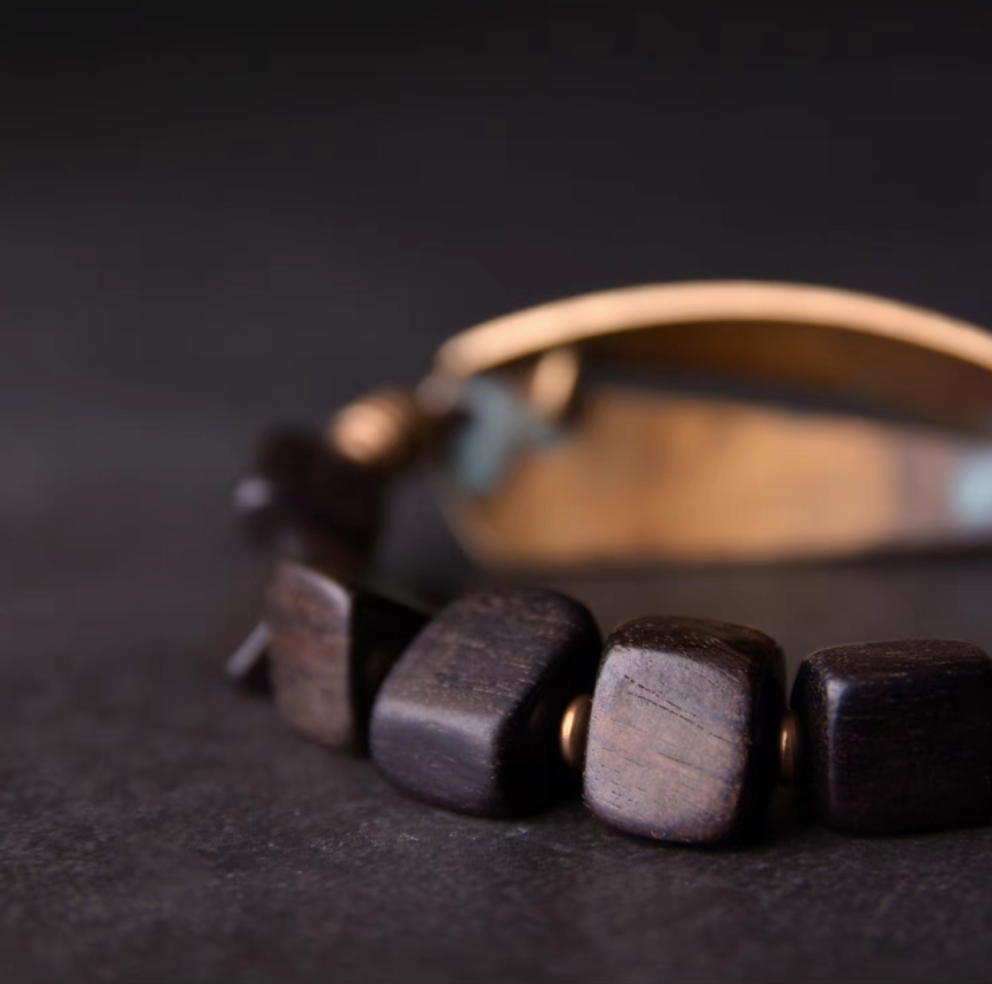 Macro detail of ebony wood beads in coffee brown tone with smooth handcrafted finish on vintage bracelet