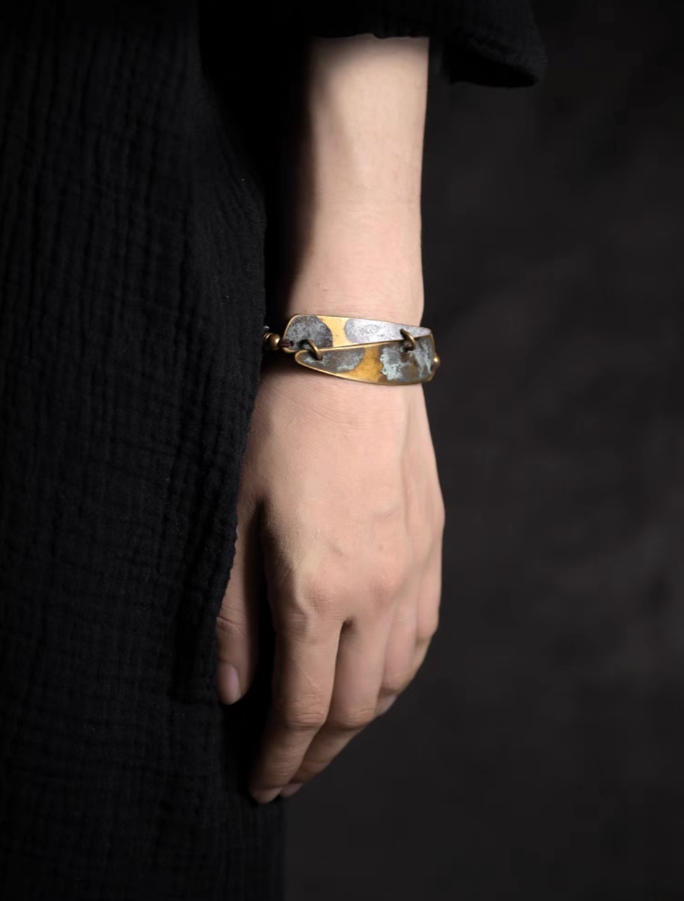Full wrist view of vintage ebony and brass bracelet with copper patina plate and natural wood bead design