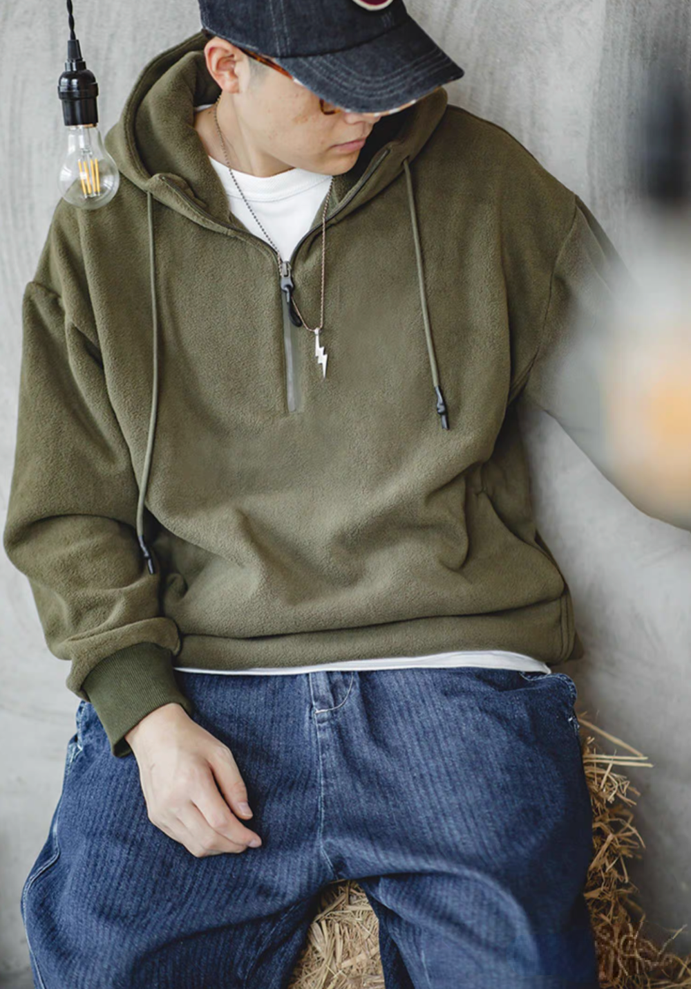 Vintage Half-Zip Fleece Hoodie in Army Green worn by seated model, casual front angled view showing relaxed fit and soft fleece texture