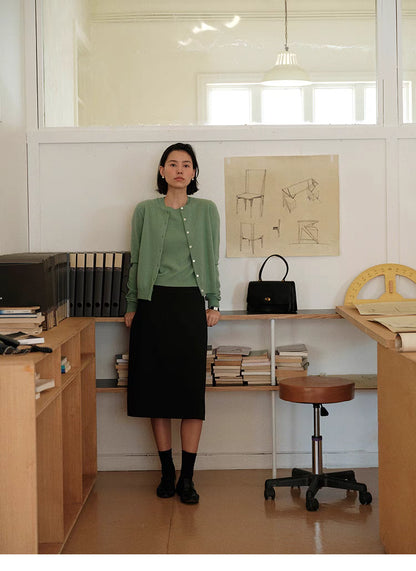 Full body look of green Vintage-Inspired Wool Cardigan paired with black skirt, minimalist vintage-inspired outfit