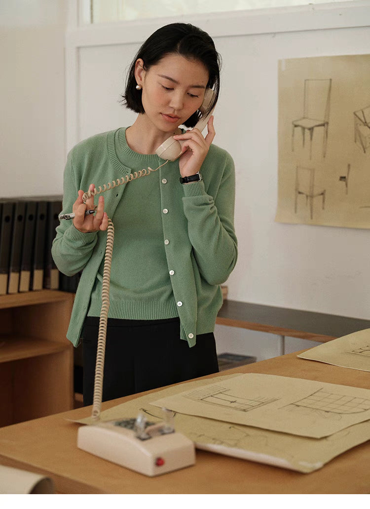 Green Vintage-Inspired Wool Cardigan styled in office setting, model holding vintage phone showcasing elegant everyday wear