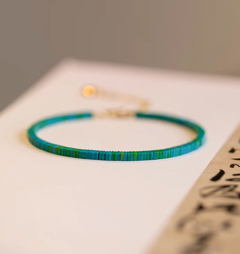 Vintage malachite bracelet in dark green tone with flat beads on a minimal background