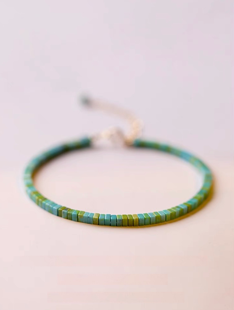 Vintage malachite bracelet in light green tone with flat square beads displayed on a clean surface