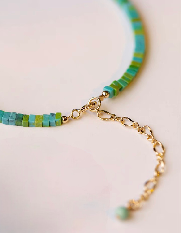 Light green malachite bracelet with gold clasp and adjustable chain detail close-up