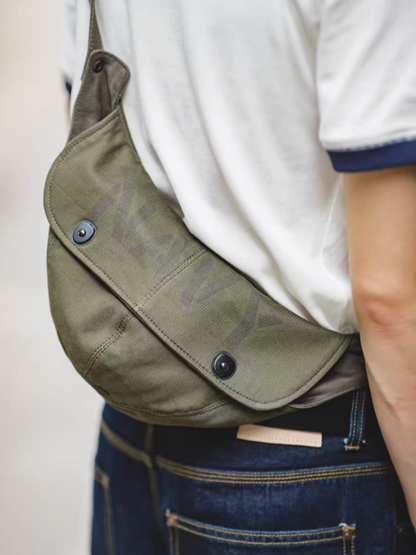 Vintage Military Canvas Sling Bag military green worn crossbody showing close-up fit and magnetic flap detail