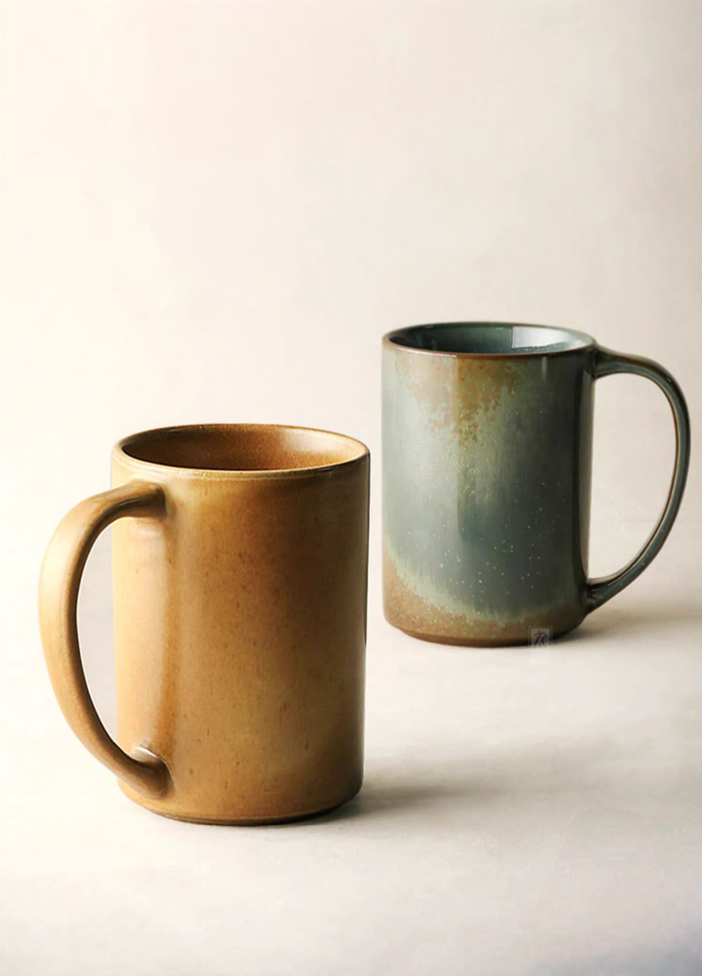 Light brown and blue gray vintage rustic ceramic mugs shown side by side highlighting gradient glaze and handcrafted texture